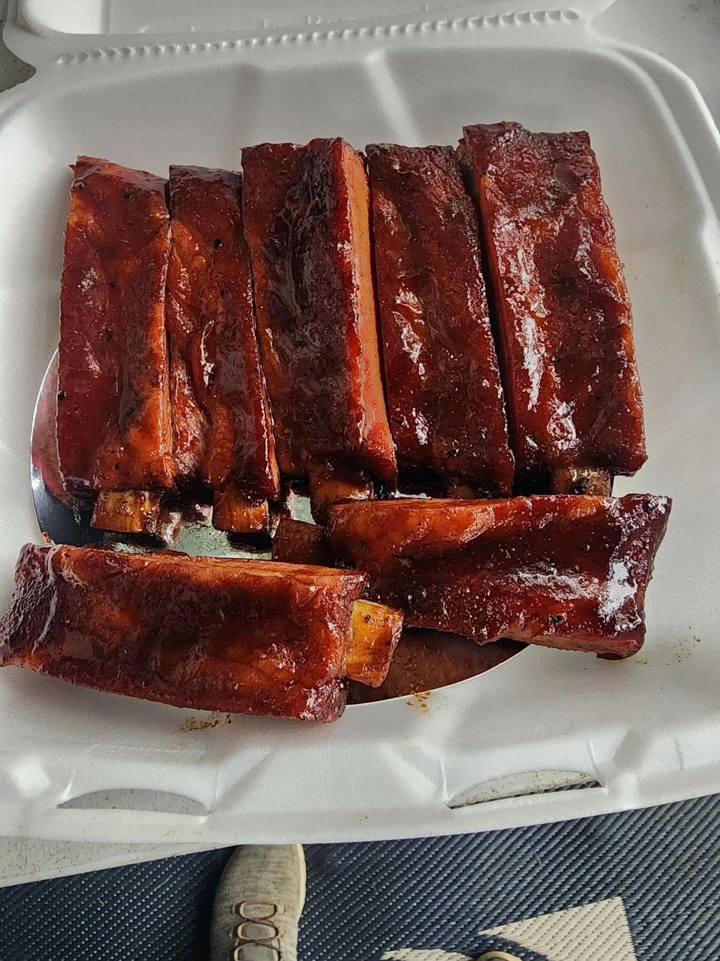 A close up of several ribs on a paper plate