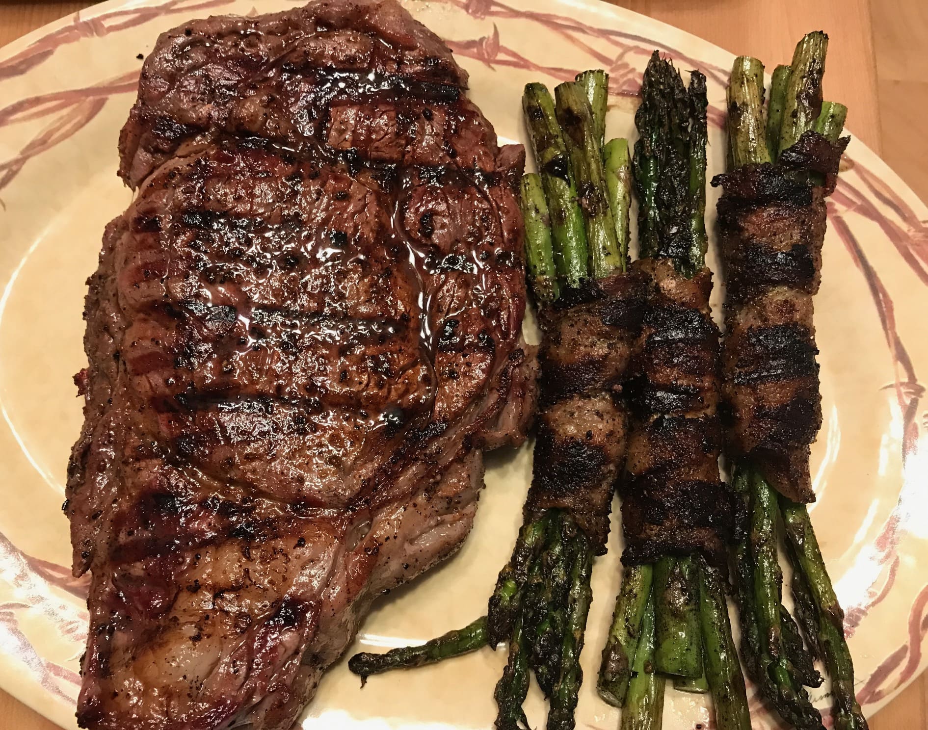 A plate of steak and asparagus on the side.
